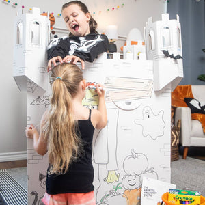 Playboxes Halloween haunted house castle image showing a girl standing inside the Halloween haunted house castle playhouse playing with another girl that is coloring the outside of the box