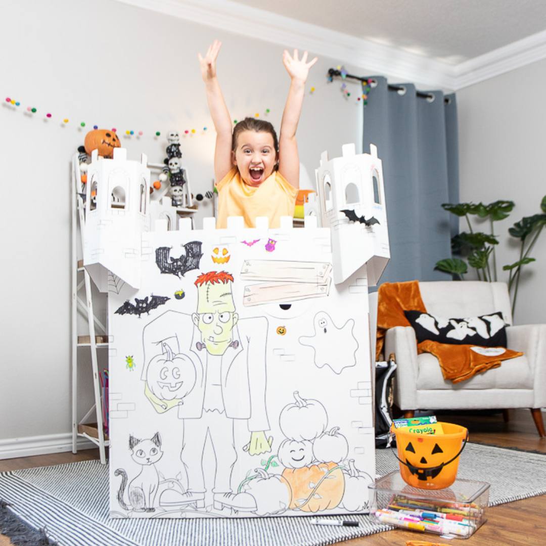 Playboxes Halloween haunted house castle image showing a girl jumping up from inside the Halloween haunted house castle playhouse with her arms up smiling
