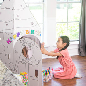 Playboxes birthday cupcake image showing girl sitting outside birthday cupcake playhouse with candle on top coloring the outside of the box