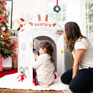 Playboxes Santa’s Workshop playhouse image showing woman and little girl sitting outside the Santa’s Workshop Christmas playhouse coloring the images printed on the the outside of the box